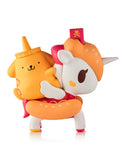 A cute unicorn figure with an orange donut mane carries a yellow dog toy with a bottle cap, both in cartoon style, from the Tokidoki x Hello Kitty & Friends Fast Food Blind Box by tokidoki (IT), shown against a white background.