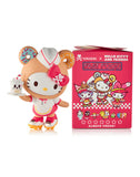 The Tokidoki x Hello Kitty & Friends Fast Food Blind Box by tokidoki (IT) features a collectible figure in a fast food-themed costume with a milkshake, next to a pink box with matching Hello Kitty and Friends fast food graphics.
