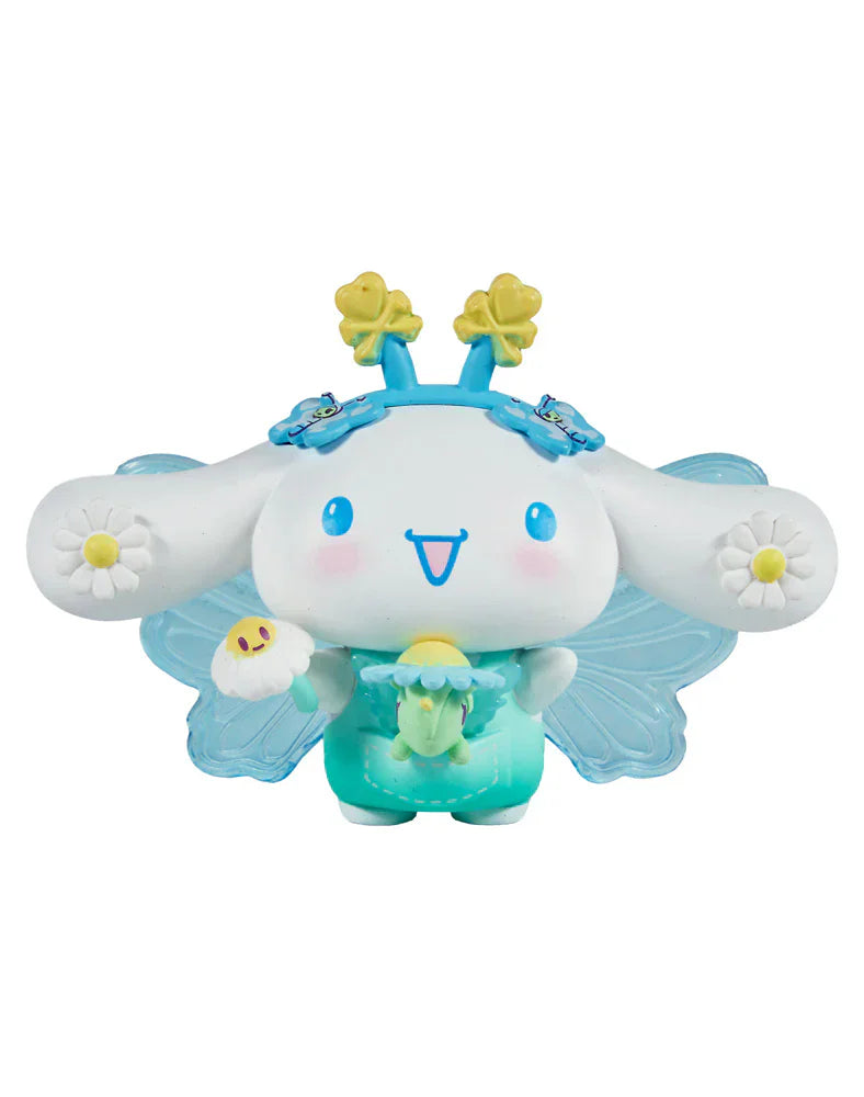 A cute cartoon with long ears, blue wings, and flower accents holding a green figure and a flower—perfect for fans of the Rotofugi Tokidoki x Hello Kitty and Friends Butterfly Garden Blind Box collectible toys.