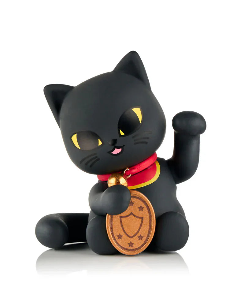 The tokidoki (IT) Tokidoki Lucky Cats Blind Box features a black collectible maneki-neko figurine with yellow eyes, a red collar, a gold coin, and an upraised left paw, displayed on a white background.