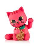 A pink Tokidoki Lucky Cats Blind Box figure by tokidoki (IT) features black whiskers, yellow eyes, and a raised paw holding a coin, resembling a Japanese Maneki-neko, set against a white background.
