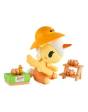 A yellow cartoon figure in an orange hat sits with toy eggs on a green