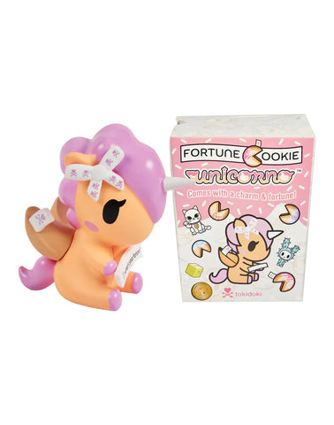 The Tokidoki Fortune Cookie Unicorno Blind Box features a pastel unicorn figurine with fortune cookie details, presented beside its charm-adorned packaging—a delightful surprise collectible for fans.