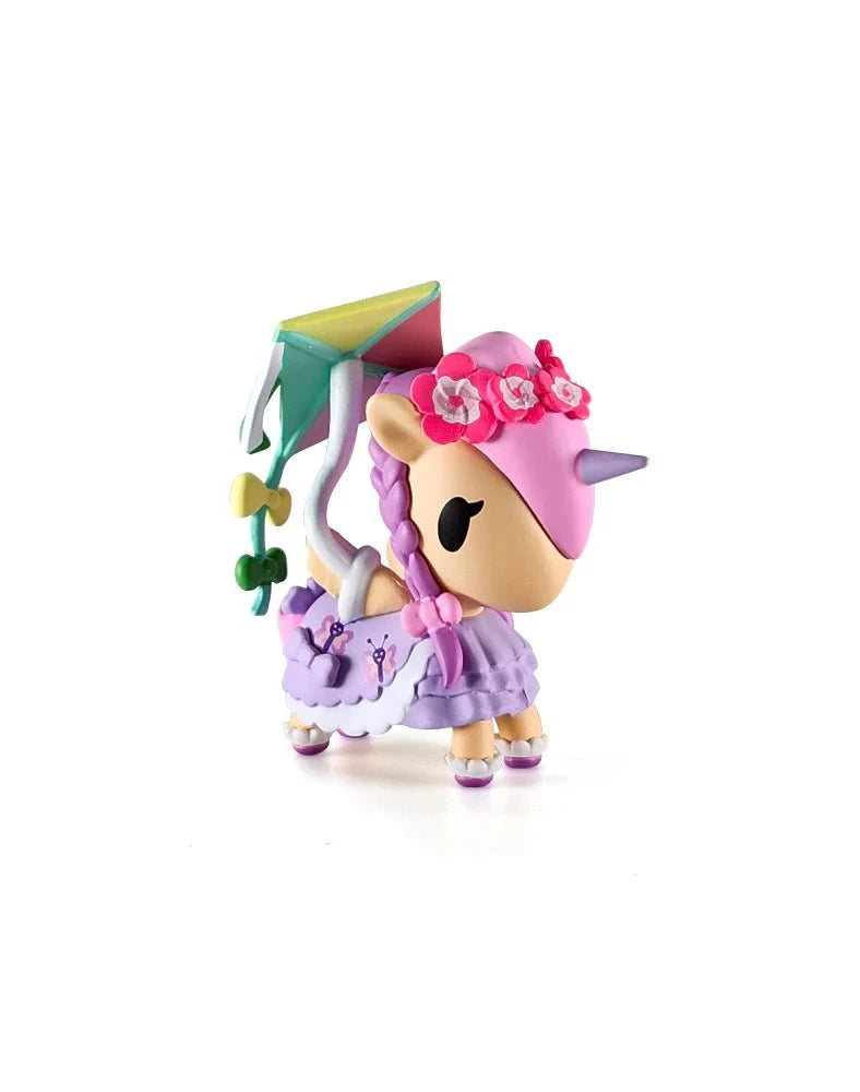 The Tokidoki Picnic Party Unicorno Blind Box by tokidoki (IT) features a cute figurine with a pink horn, purple mane, flower crown, kite on its back, plus a frilly lavender skirt and apron—ideal for any tokidoki blind box collector.