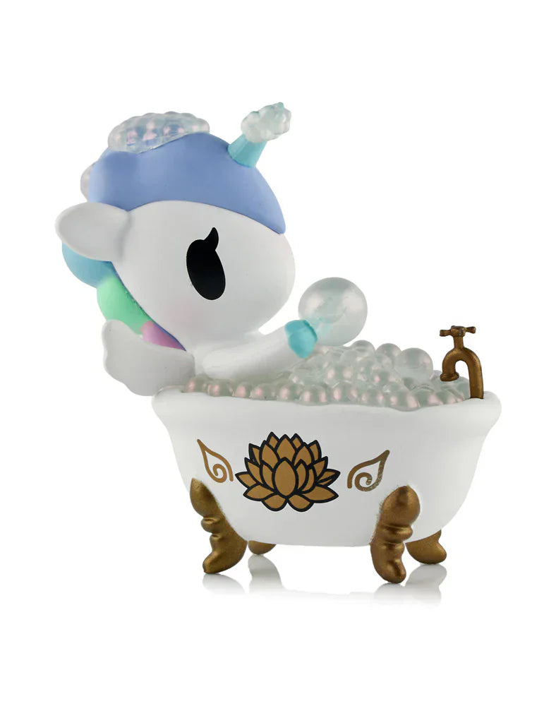 The Tokidoki Spa Day Unicorno Blind Box features a pastel Unicorno in a white bathtub with gold legs and lotus accents, surrounded by bubbles—an adorable kawaii wellness collectible for any fan.