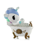 The Tokidoki Spa Day Unicorno Blind Box features a pastel Unicorno in a white bathtub with gold legs and lotus accents, surrounded by bubbles—an adorable kawaii wellness collectible for any fan.