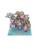 Celebrate tokidoki’s 20th Anniversary with the Tokidoki 20th Anniversary Acrylic Standee Blind Box—featuring colorful cartoon characters like a girl, milk and latte cartons, and sweets on a blue checkered base.