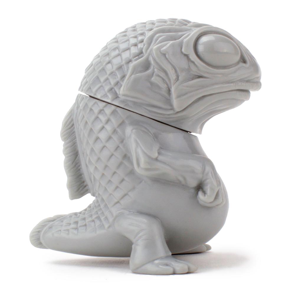 A Snybora - Unpainted/DIY toy fish resting on a white surface by Squibbles Ink + Rotofugi.