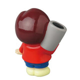 A small collectible figure from Medicom’s Vinyl Artist Gacha Series 13—Fumharu Kun—features a large round head, red shirt, blue pants, and yellow shoes, holding a gray cylinder over its right shoulder while facing away.