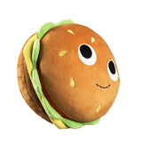 The Kidrobot (US) Bunford Burger - 10 inch Yummy World Plush is a burger-shaped plush toy with lettuce and tomato layers, plus large cartoon eyes and a small smile on the bun.