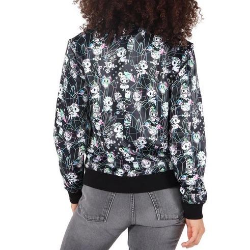 A woman wearing a Tokidoki Crystal Palace satin bomber jacket with an all-over print of flowers on it.