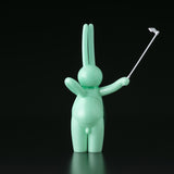 A green bunny figurine holding a golf club, designed by Mr. Clement in Japanese vinyl from Tomenosuke Shoten (JP), called The Daily Flasher by mr. clement.