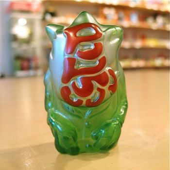 A Popsoda Finger Puppet - Clear Green frog sitting on a table, ready for a puppet show.