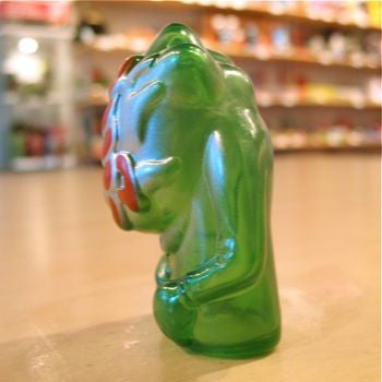 A Popsoda Finger Puppet - Clear Green sitting on a table.