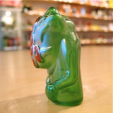 A Popsoda Finger Puppet - Clear Green sitting on a table.