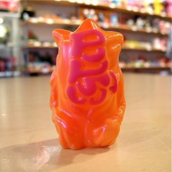 A tiny Popsoda Finger Puppet - Orange perched on a table.