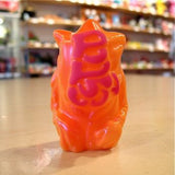 A tiny Popsoda Finger Puppet - Orange perched on a table.