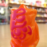 A Popsoda Finger Puppet - Orange and pink sits on a table.