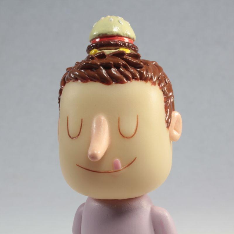 A sculptor created a figure of a man with a Tinder Toys: Boyger on his head.