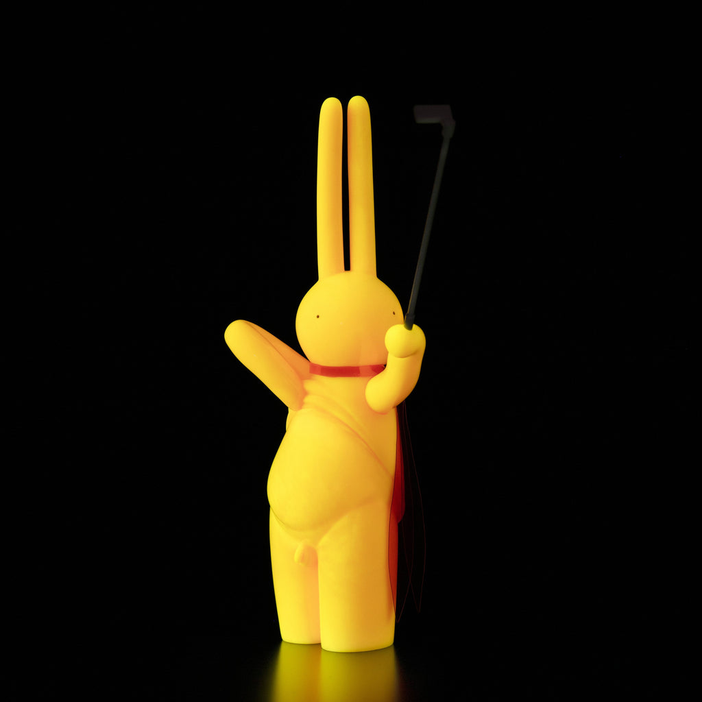 A yellow bunny holding a golf club on a Tomenosuke Shoten (JP) vinyl background featuring The Daily Flasher by mr. clement.