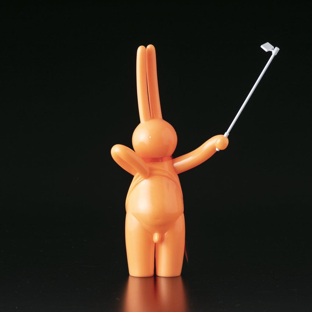 An orange bunny holding The Daily Flasher by mr. clement, a Japanese vinyl golf club by Tomenosuke Shoten (JP).
