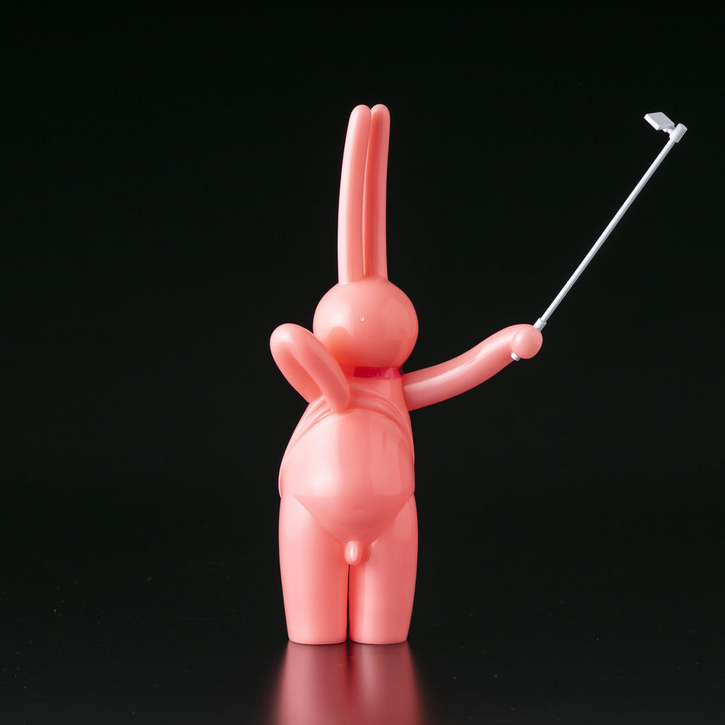 A pink bunny holding a golf club on a black background, created by The Daily Flasher by mr. clement from Tomenosuke Shoten (JP).