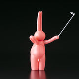 A pink bunny holding a golf club on a black background, created by The Daily Flasher by mr. clement from Tomenosuke Shoten (JP).