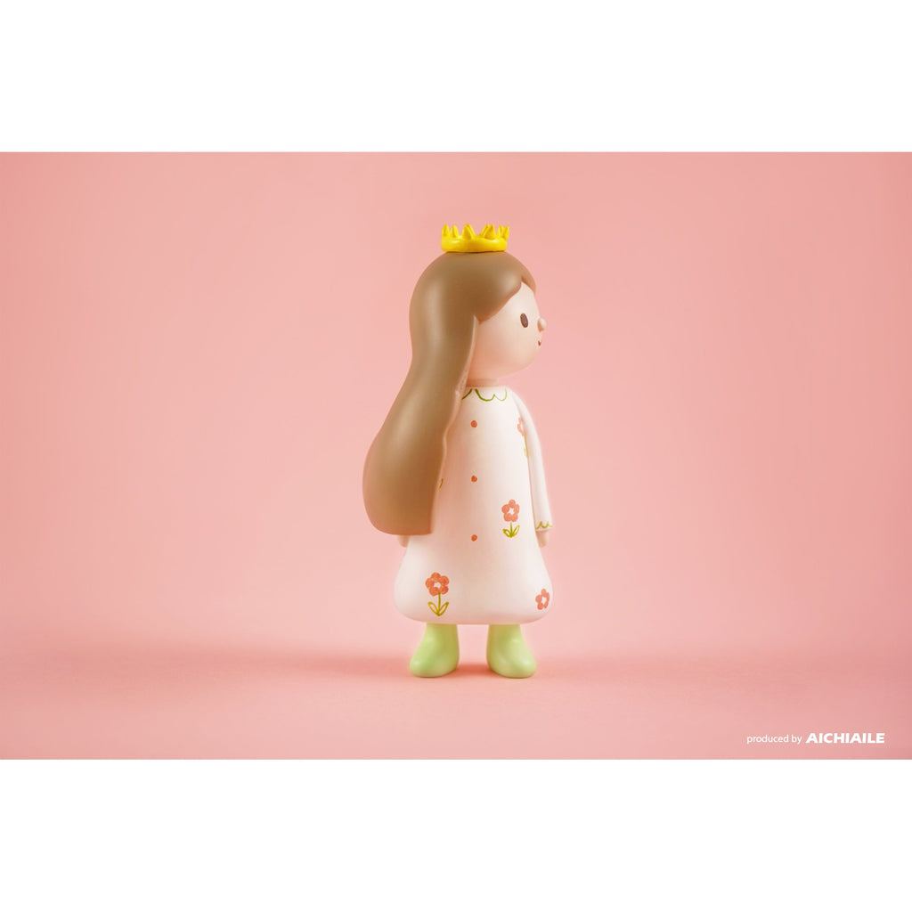 Queency resin figure with a crown on a pink background.