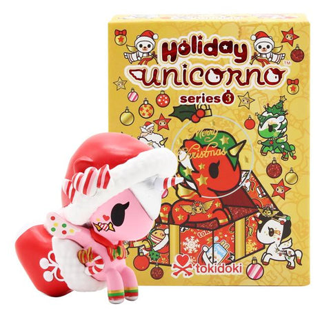 A little unicorn in front of a Christmas box from the tokidoki Holiday Unicorno Series 3 Blind Box spreads holiday cheer.