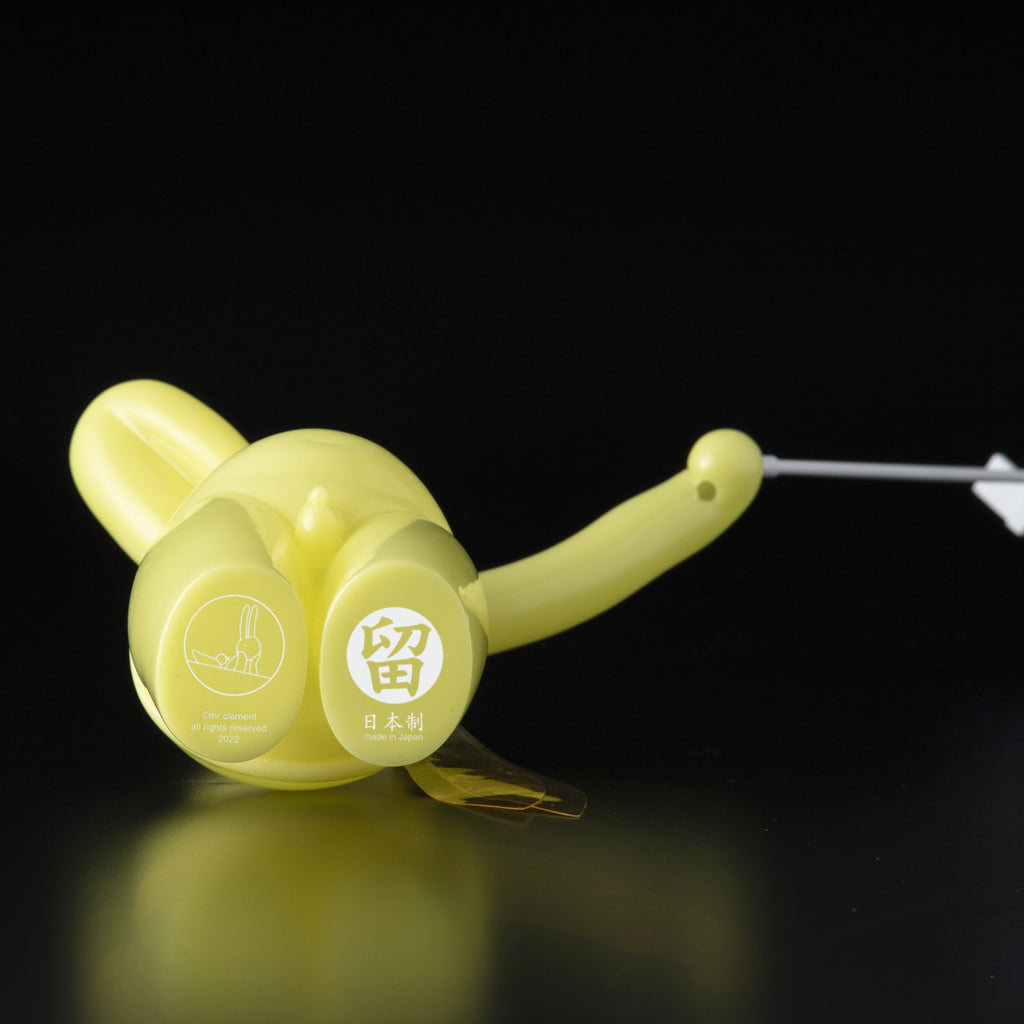 A yellow Japanese vinyl toy with an arrow sticking out of it, The Daily Flasher by Tomenosuke Shoten.