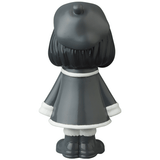 A black and white figurine of a girl wearing a hat, reminiscent of Japanese vinyl toy artists, like the VAG 31 β Uramy and Tsurami by Medicom (JP).
