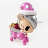 A pink tokidoki Holiday Unicorno Series 2 Blind Box chase figure with silver mane, wings, and horn, Santa hat, gold present, and white stars—an adorable collectible for any fan!.