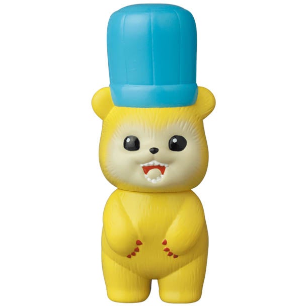 A yellow VAG Series 28 β Koguma Kekiyasan teddy bear with a blue hat, modeled after Japanese vinyl toys by Medicom (JP).