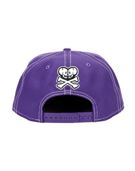 A Lavender Dragon Snapback hat with an embroidered skull and crossbones design by tokidoki.