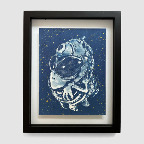 Alien Ghost 2 by Lindsay Wailes DiFabbio (EX102025-01), a framed artwork from Rotofugi, features a stylized one-eyed alien with a large head and hands set against a starry blue background.