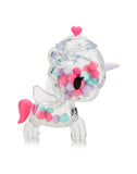 Experience the charm of Tokidoki's Sugar Shop Unicorno: a clear unicorn figure featuring a pink tail, wings, and purple horn, filled with candy-like beads. Ideal for collectors, each comes in a blind box adding surprise!.