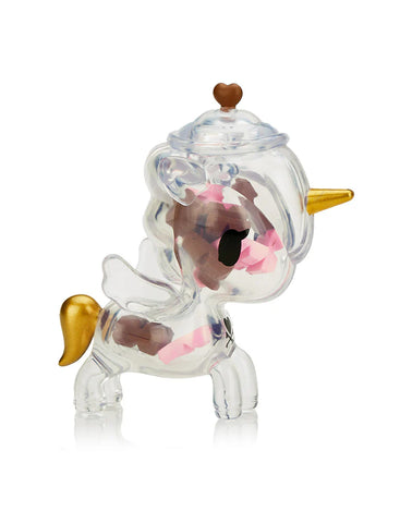 The Tokidoki Sugar Shop Unicorno Blind Box offers a charming, candy-themed unicorn figurine with a gold horn and tail, dark eyes, small wings, pink accents inside a transparent body, and a small brown heart on its head.