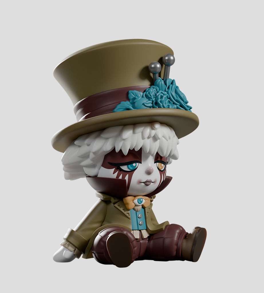 The A Mad Tea Party Blind Box by Kaleidos Creative features a circus clown-inspired vinyl figure with a large top hat, white hair, brown and white face paint, and a green coat—an ideal collectible for any blind box fan.