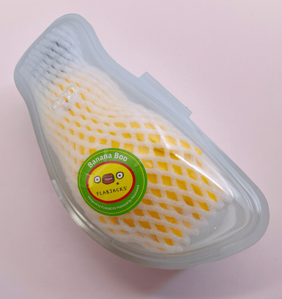 The Banana Boo - Yellow by Rotofugi is packaged in white foam and a clear plastic container with a green 