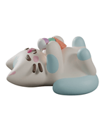 A cartoon-style cat figure with blue paws lies on its back, holding colorful objects like an orange fish—reminiscent of the whimsical Kaleidos Creative Bake Me A Cat Blind Box figures.