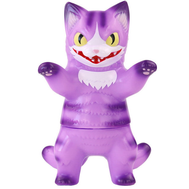 The Konatsuya Cheshire Cat Negora is a purple, cartoonish cat figurine with yellow eyes, sharp teeth, and white markings, standing upright with raised paws and a mischievous grin—an eye-catching collectible for any fan.