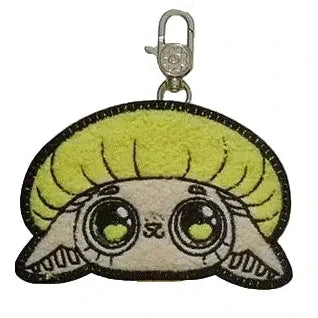 Collectible keychain from Kaleidos Creative, featuring a cute cartoon animal face with big eyes, tan fur, and a lime-green round hairstyle—perfect for Capkins Mystery Coin Bag fans or adding to your blind box collection.