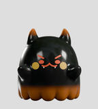 A glossy black and orange cat-like figure with fangs, rounded ears, and an angry expression from Kaleidos Creative’s Cute as Heck! Blind Box collection—ideal for collectible figure and blind box fans. Set against a plain gray background.