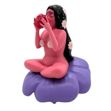 Flower Girl by UVD Toys (US) features a pink-skinned woman with long black hair and flowers, sitting cross-legged on a purple cushion and holding a pink fruit—an enchanting collectible that makes a unique gift.
