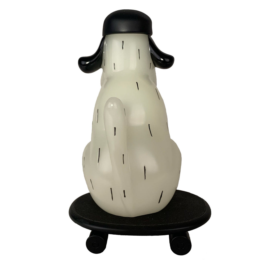 The One-Chu SK8 - Glow by How 2 Work features a stylized white figure with black ears and tail, sitting on a round black skateboard-style platform with wheels, shown from the back.