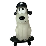 The One-Chu SK8 - Glow figure by How 2 Work features a cartoonish dog in a black cap sitting on a black skateboard, displayed against a plain white background.