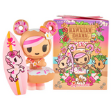 A tokidoki Hawaiian Ohana Blind Box vinyl figurine with donut bear ears, a lei, and a pink surfboard stands by its colorful, cartoon-art box.