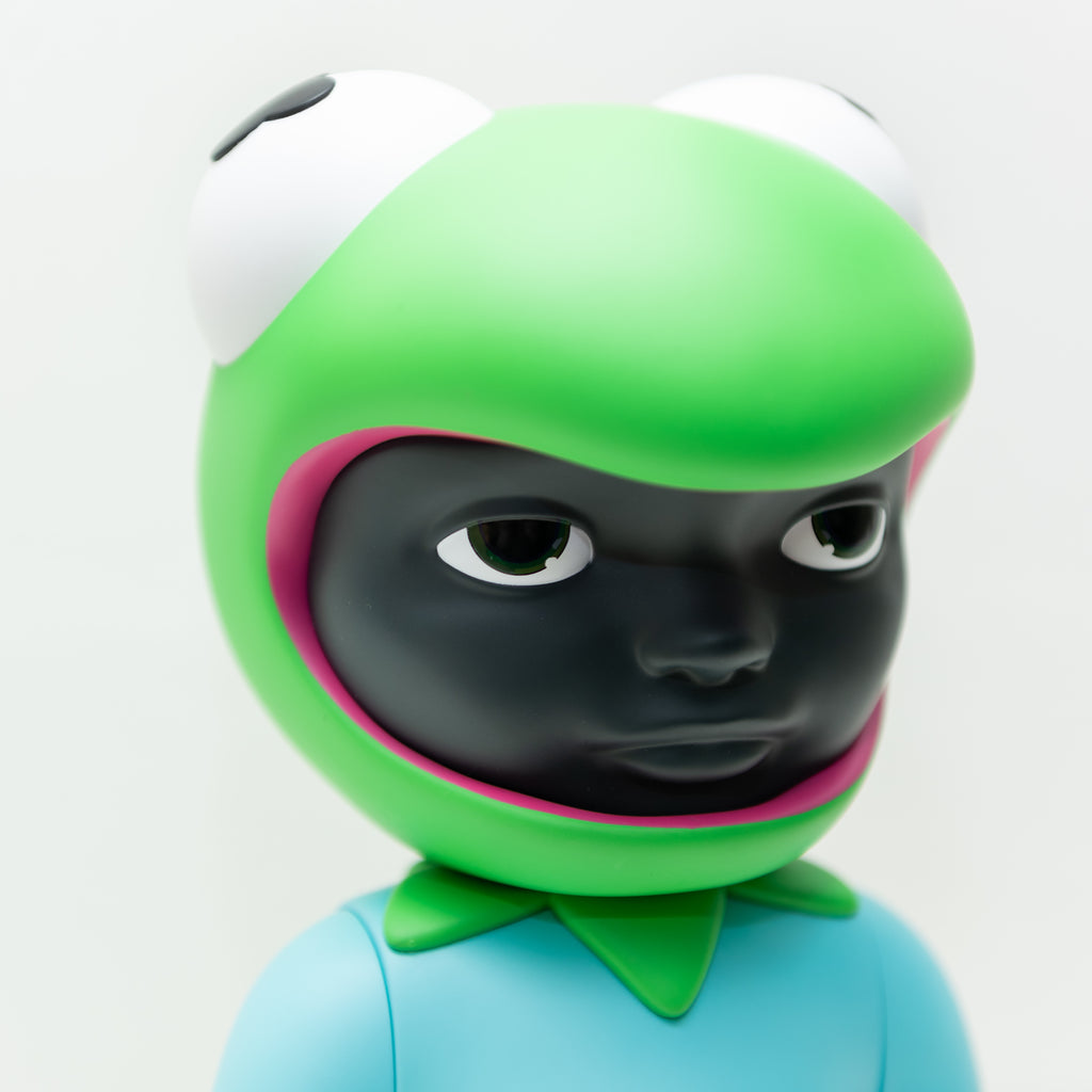 Introducing Phibby — OG (Green) by Hebru Brand (US): A limited edition vinyl figurine featuring a green frog hat, large white eyes, and a serious expression, dressed in a blue shirt with a green collar.