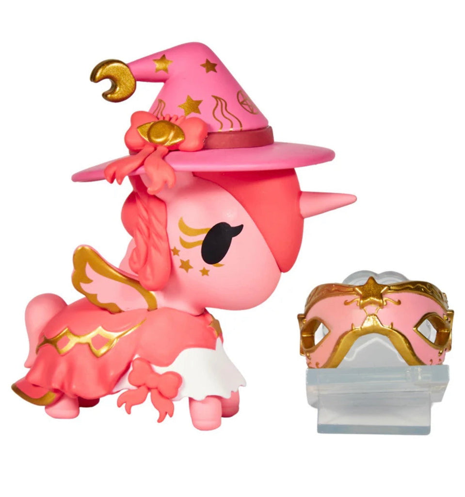The Tokidoki Unicorno After Dark Masquerade Blind Box features a pink unicorn figurine with gold accents, a wizard hat, wings, and a matching ornate pink and gold mask displayed on its stand.