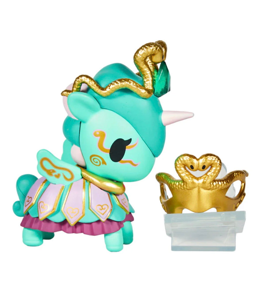 The Tokidoki Unicorno After Dark Masquerade Blind Box features a turquoise collectible figurine with gold accents, a snake-inspired headdress and crown, and comes on a clear stand—ideal for any Blind Box collection.